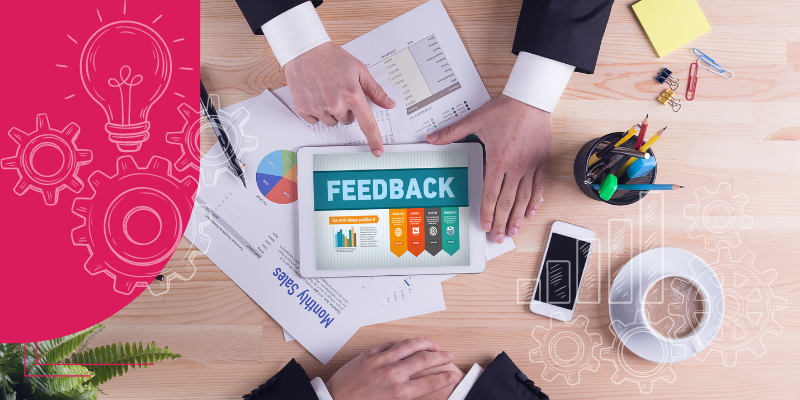 Smartphone com balões de conversa simbolizando feedback imediato, relógio indicando gestão de tempo e planta agregando vida à mesa de escritório.