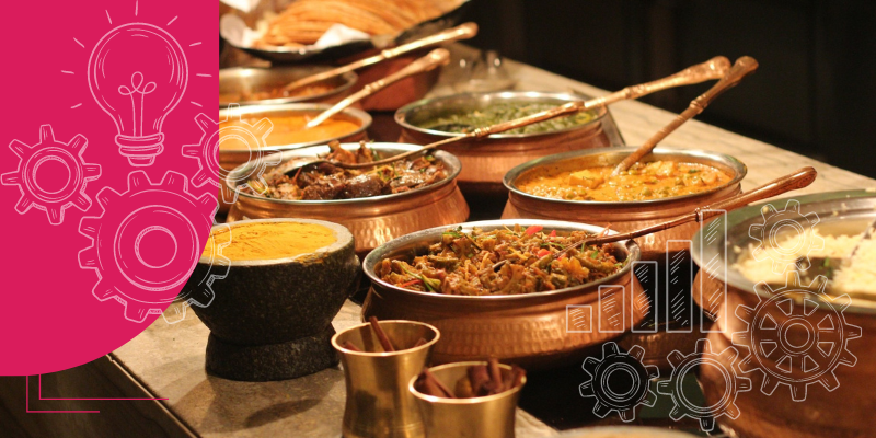 Imagem de uma mesa de buffet sofisticada e bem decorada com pratos variados e coloridos, representando o serviço de catering profissional.
