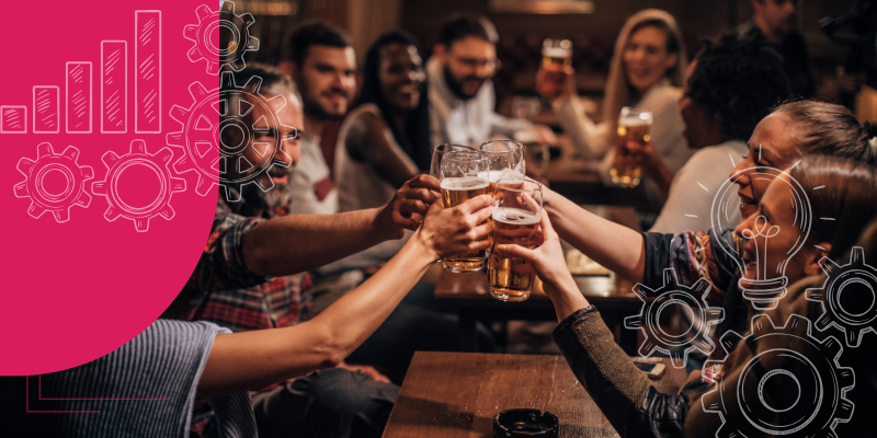 Bar aconchegante com mesas de madeira, pessoas conversando e bartender servindo coquetéis coloridos.