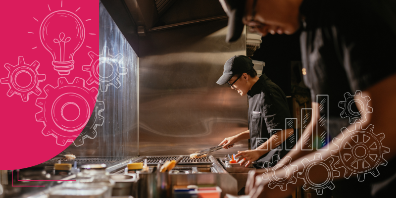 Cozinha movimentada com chefs fatiando vegetais e cozinhando em fogões, com uma grande relógio marcando 12:30.