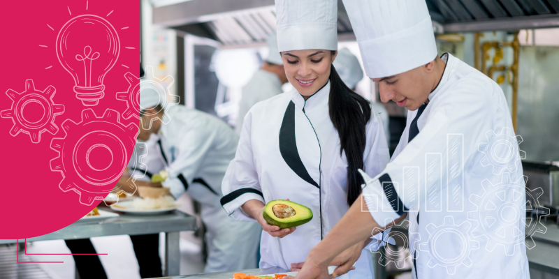 Chefs em uniformes brancos cozinhando pratos coloridos em uma cozinha movimentada de restaurante com ingredientes e utensílios frescos.