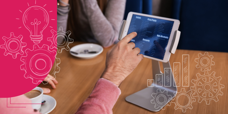 Tablete moderno com menu digital ao lado de prato de massa gourmet, salada e vinho em restaurante elegante.