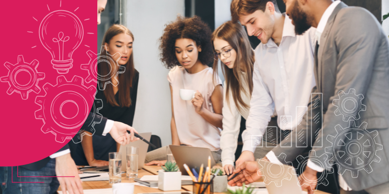 Pessoas em reunião de negócios no escritório, com laptops, smartphones e papéis sobre a mesa.